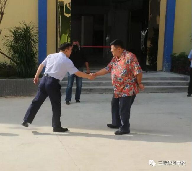 海南中学马向阳校长与三亚华侨学校何坚董事长握手